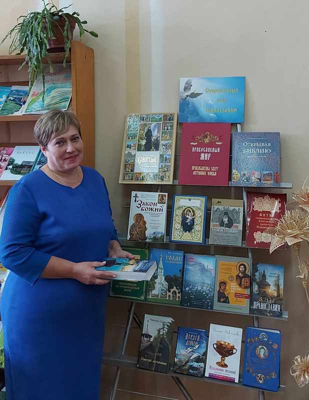 Библиотекарь Валентина Буко возле книжной выставки «Духовной радости сияние»